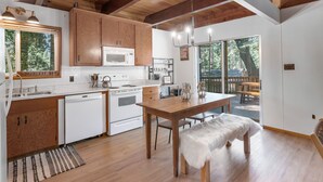 Una cucina moderna con mobili in legno, elettrodomestici bianchi e un'area pranzo con una panca.
