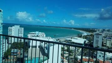 Um edifício alto com vista para a praia e o oceano.