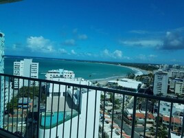 Un edificio alto con vista a la playa y al océano.