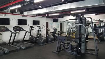A gym with treadmills, elliptical machines, and weightlifting equipment.