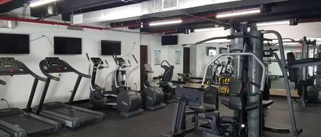 A gym with treadmills, elliptical machines, and weightlifting equipment.