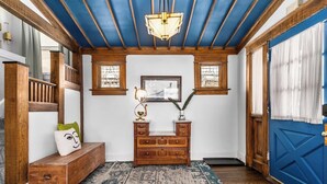 A hallway with a wooden bench, a small wooden dresser, and a patterned rug. - Spacious Home in KC's Core 46 (Kansas City)