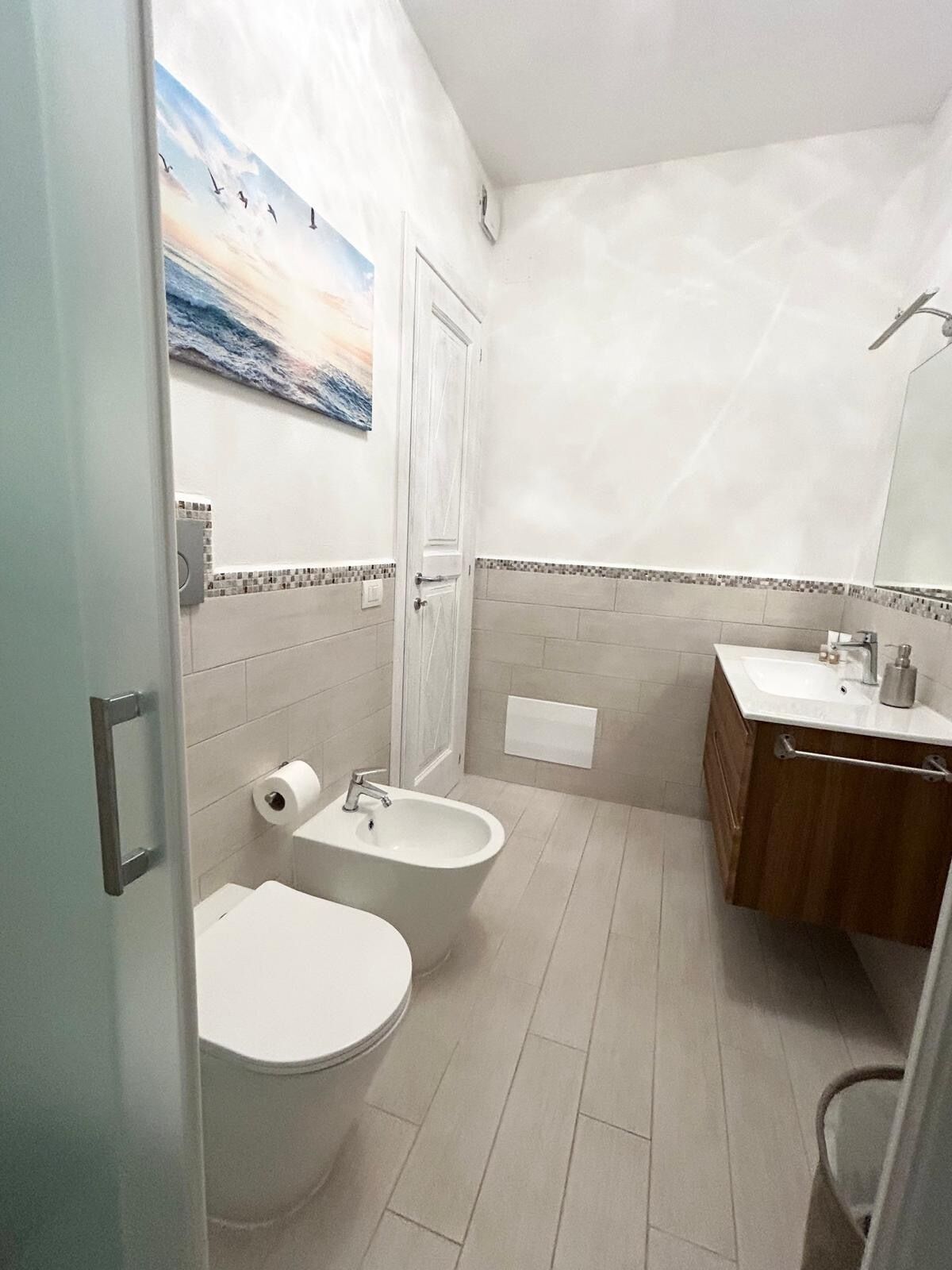 A bathroom with a toilet, bidet, and sink.