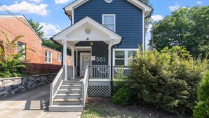 A two-story house with a front porch, a mailbox, and a number '561' on the door.