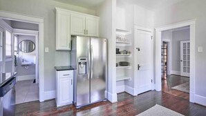A modern kitchen with white cabinetry, a stainless steel refrigerator, and a built-in oven. - Downtown Raleigh: Spacious, Pet-Friendly, Fenced (Raleigh)