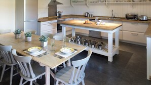 A modern kitchen with a central island, white cabinetry, and a variety of kitchen appliances.