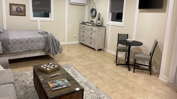 Un dormitorio con cama, cómoda, escritorio, silla y televisión.