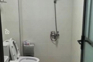 Un baño con inodoro, ducha y secamanos.
