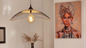 A dining area with a modern chandelier, a large abstract painting, and a fireplace.