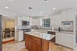 Enjoy cooking in this well-equipped kitchen with a large island, refrigerator, microwave, and oven.