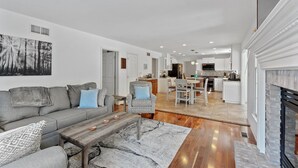 A spacious living area with a grey sofa, a wooden coffee table, and a patterned rug.