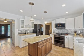 Enjoy cooking in this well-equipped kitchen with a central island, stainless steel appliances, and ample counter space.