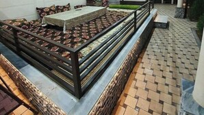 A restaurant with a long communal table, a kitchen area with a grill, and a tiled floor. - Villa "Milano" in Chorvoq, Tashkent (Тошкент)