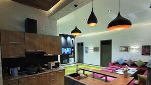 A modern kitchen with wooden cabinets, a central island, and pendant lighting. - Villa "Milano" in Chorvoq, Tashkent (Тошкент)