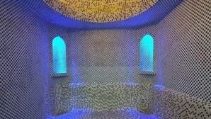 A room with a patterned floor, a bed, and two illuminated windows. - Villa "Milano" in Chorvoq, Tashkent (Тошкент)