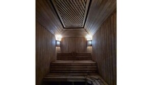 A sauna with wooden benches and sloped ceilings. - Villa "Story" in Chortoq, Tashkent (Тошкент)