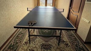 A ping pong table in a hotel room with a view of a bridge through the window. - Rapunzel villa (Тошкент)