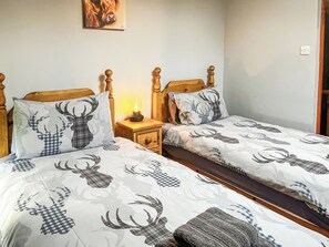 A double bed with a checkered deer pattern, a bedside table with a lamp, and a painting on the wall. - 2 bedroom accommodation in Bakewell (Bakewell)