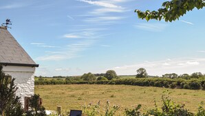 A rural landscape with a white house, a field, and a clear sky. - Picked for its charm and character and close to a plethora of walks. (Crundale, near Haverfordwest)