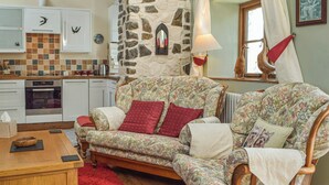 A cozy living room with a floral sofa, a wooden coffee table, and a red rug. - Picked for its charm and character and close to a plethora of walks. (Crundale, near Haverfordwest)