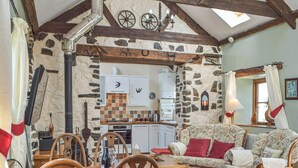 A rustic interior with a stone wall, wooden furniture, a dining table, and a kitchen area. - Picked for its charm and character and close to a plethora of walks. (Crundale, near Haverfordwest)