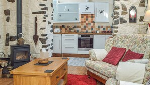 A cozy living room with a fireplace, a sofa, and a wooden coffee table. - Picked for its charm and character and close to a plethora of walks. (Crundale, near Haverfordwest)