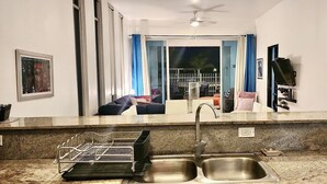 A modern kitchen with granite countertops, a stainless steel sink, and a dish drying rack.