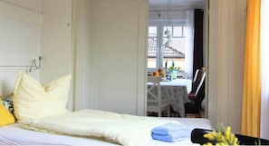 Ein Schlafzimmer mit einem Bett, Kissen, einem Tisch und einem Stuhl.