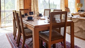 Zona pranzo con tavolo in legno, sedie e lampadario.