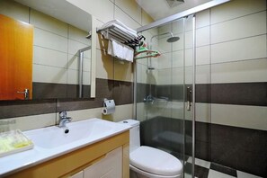 A bathroom with a shower, toilet, sink, and a mirror. - Mindu Business Hotel (Anxi)