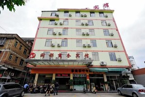A multi-story building with a flat facade, multiple windows, and a covered entrance area. - Mindu Business Hotel (Anxi)