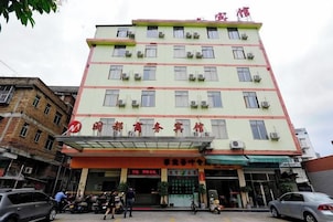A multi-story building with a flat facade, multiple windows, and a covered entrance area.