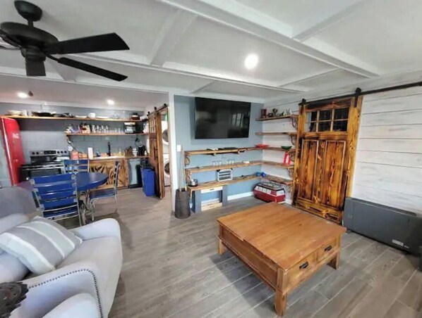 Relax in this stylish living space with a comfortable sofa, coffee table, and mounted TV.