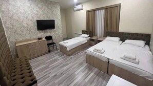 A hotel room with a bed, a desk, a chair, a TV, and a window with curtains. - Mazza Plaza(Joy hotel) (Тошкент)