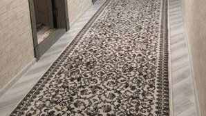 A hallway with patterned carpet, a bench, and a door. - King sized bed,luxury house (Тошкент)