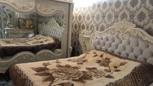 A bedroom with a large mirror, ornate bed frame, and floral bedspread. - King sized bed,luxury house (Тошкент)