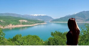 A woman overlooking a lake with mountains in the background. - Best place for vacation (Тошкент)