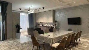 A modern dining area with a rectangular table, six chairs, and a kitchen in the background. - Best place for vacation (Тошкент)