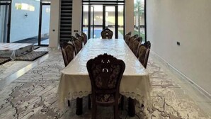 A conference room with a long table, chairs, and a patterned floor. - Palma Villa (Тошкент)