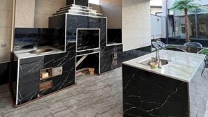 A modern kitchen with a central island, built-in appliances, and a view of the outdoors. - Palma Villa (Тошкент)