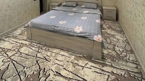 A bedroom with a bed, nightstands, a window, and a patterned floor. - Palma Villa (Тошкент)