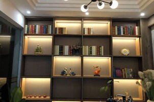 Una estantería con varios niveles, algunos con libros y otros con objetos decorativos.