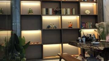 A modern interior with a bookshelf, a wooden bench, and a table with decorative items.