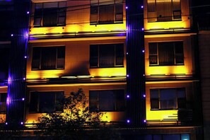 A multi-story building with illuminated windows and vertical light strips. - Kevin Boutique Hotel (Guilin)