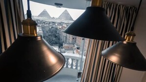 A room with two hanging lamps and a view of the pyramids. - Pyramids Bay Apartment the best place to view the Giza Pyramids (Giza Governorate)