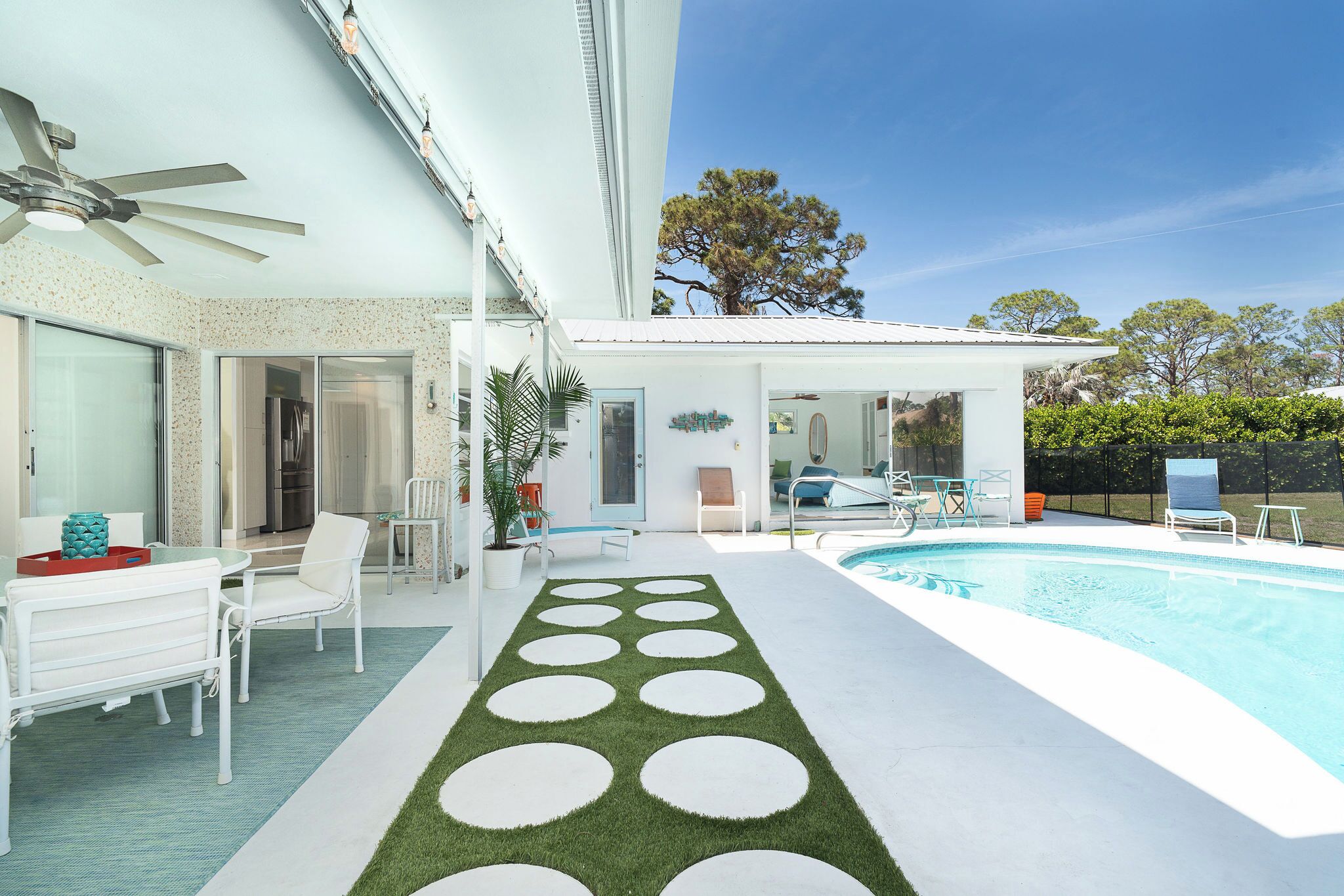Ein modernes Haus mit Pool, Außenbereich und überdachter Terrasse.
