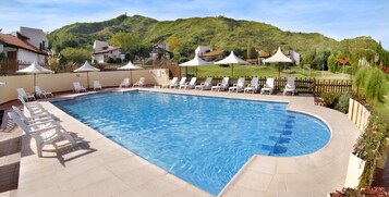 Una piscina cubierta, una piscina al aire libre de temporada, sombrillas