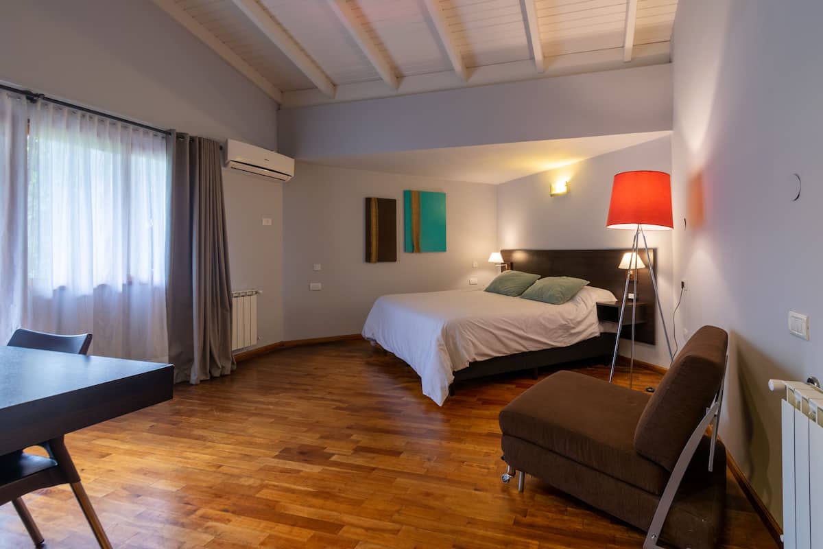 Une chambre moderne avec un lit, un canapé, une table à manger et une lampe.