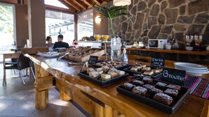 A buffet with various desserts and a stone wall in the background. - Harmonie Hotel de Montaña (Villa General Belgrano)