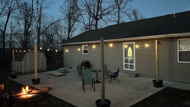 A backyard with a fire pit, outdoor furniture, and string lights. - Bull Shoals Lake House -  Marina & Restaurant Near (Theodosia)